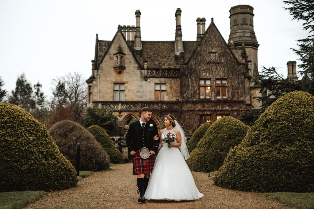 Bride and groom in front of manor house