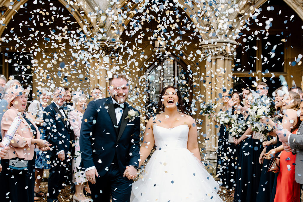 Bride & Groom having a confetti photo in front of the Manor arches