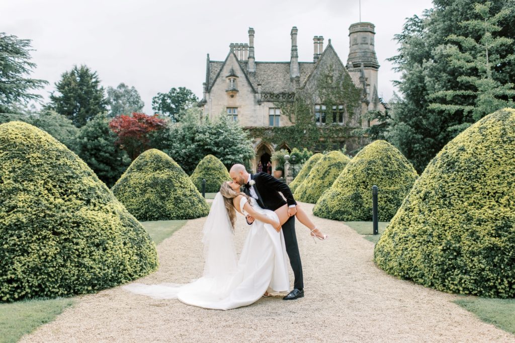 bride and groom dip kiss at manor by the lake